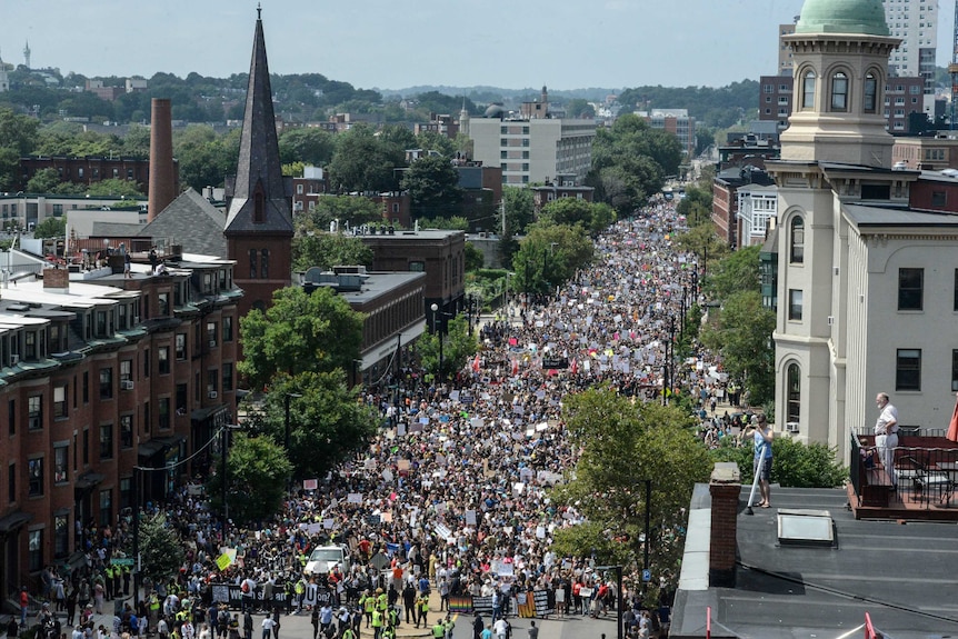 View of the march from a tall building. The street is filled with people holding placards.