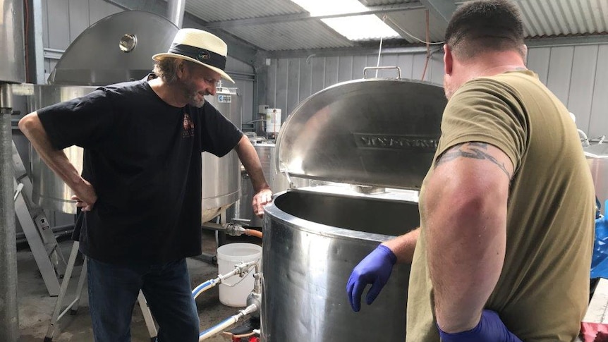 Brewers Willie Simpson and Paul Wallace peek into a brewing vat at the Seven Sheds brewery at Railton