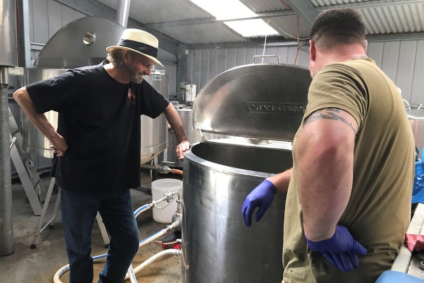 Brewers Willie Simpson and Paul Wallace peek into a brewing vat at the Seven Sheds brewery at Railton