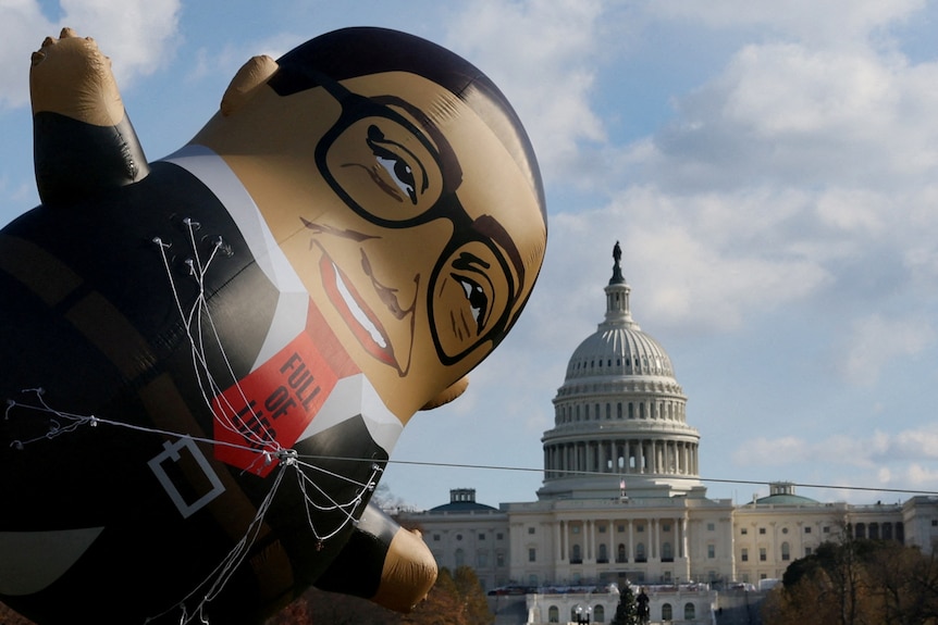 A giant balloon, a likeness of George Santos with a tie that says 'full of lies', is seen in front of the Capitol building.