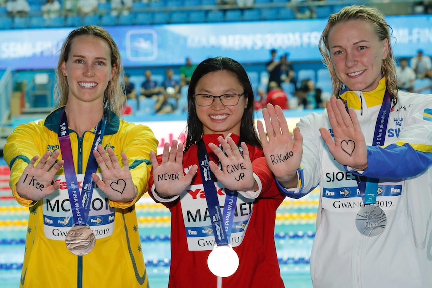 Emma McKeon, Margaret MacNeil and Sarah Sjostrom's palms show a loving message for Rikako Ikee at swimming world championships.