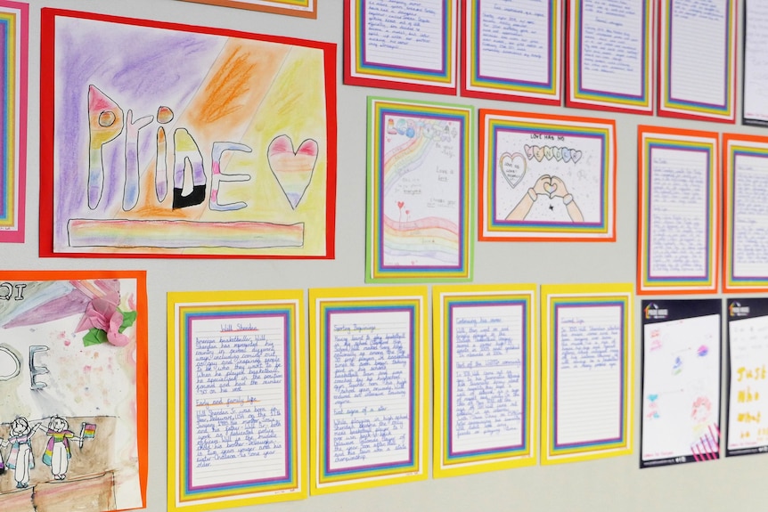 A number of kids' artworks displayed on a wall, including one saying 'PRIDE'