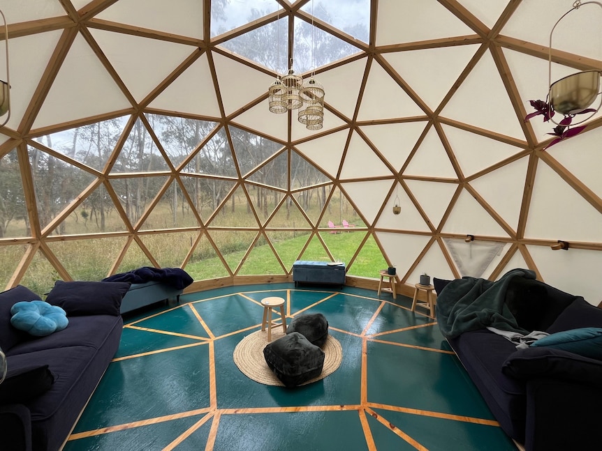 Un salón dentro de una gran cúpula con árboles afuera.