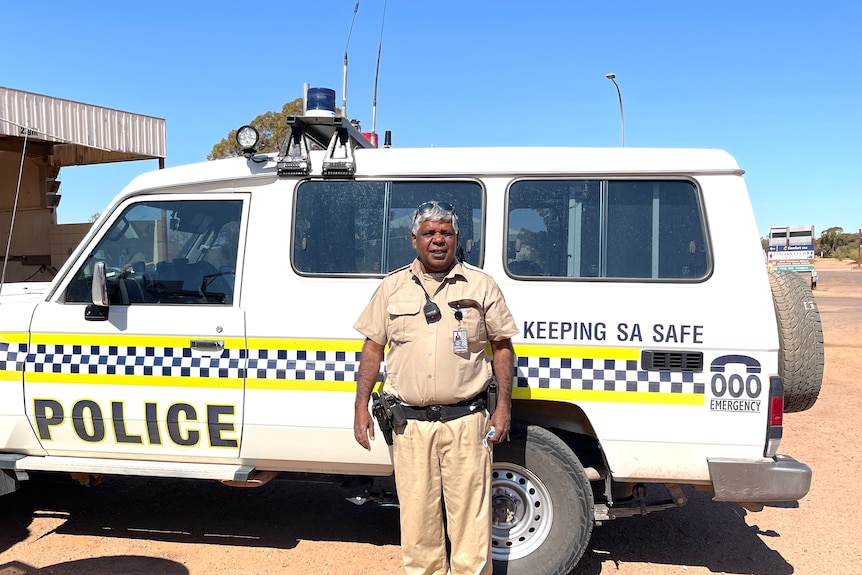 a man standing in front of a police car