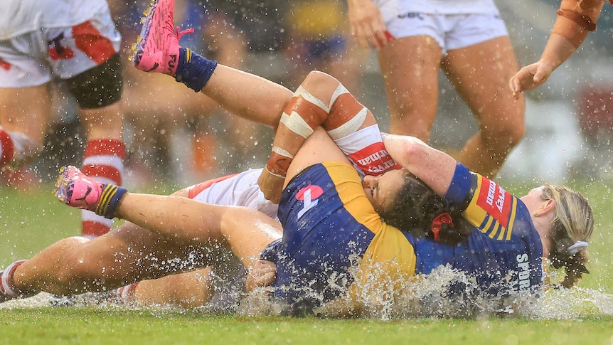 A player tackles another player during a women's rugby league match 