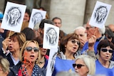 Protesters hold up signs depicting the famous painting by Edvard Munch, The Scream.