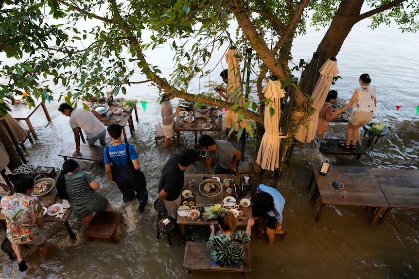 Thực khách ngồi giữa một nhà hàng ngoài trời ngập nước
