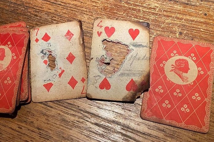 Old looking playing cards fanned out on a wooden table