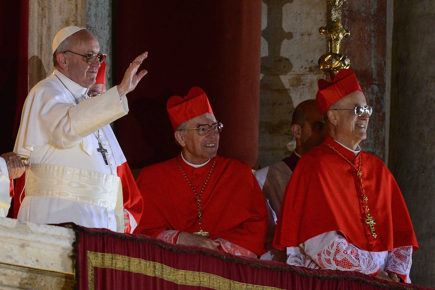 Pope Francis appears on the central balcony of St Peter's Basilica.