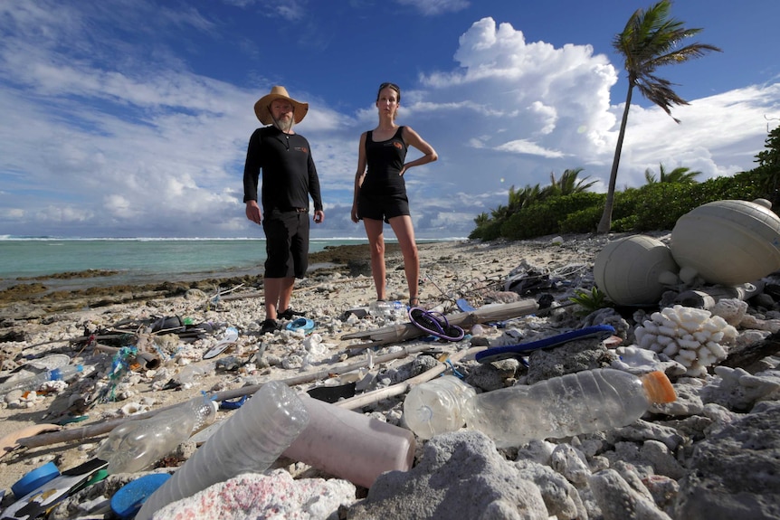 Scientist Jennifer Lavers standing behind marine debris on a beach in the Cocos (Keeling) Islands.
