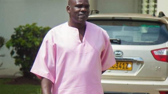 You view Ladislas Ntaganzwa in a bright pink shirt in harsh sunlight.