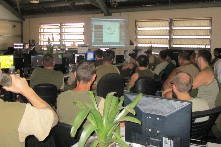 Prisoners at a high security facility near Ipswich sit in a classroom learning about graphic design and 3D animation.