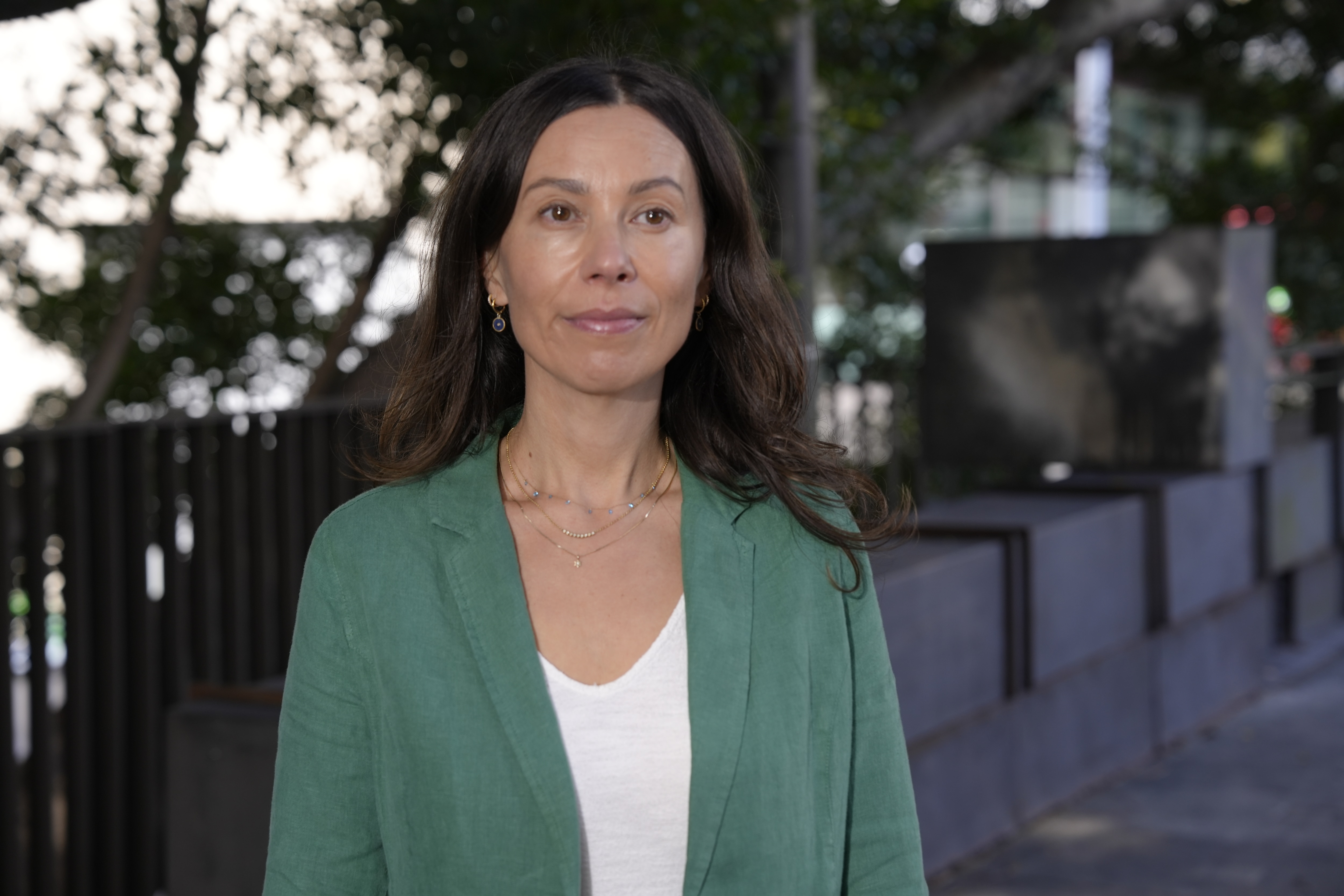 An academic in a green blazer outdoors.