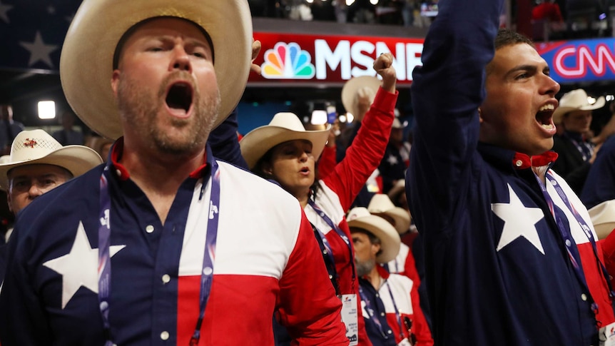 Texans in American-themed clothing yell on the floor of the Republican National Convention.