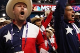 Texans in American-themed clothing yell on the floor of the Republican National Convention.