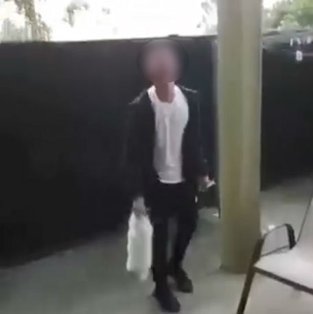 A video still showing the moment before a man throws a rabbit up to the roof of a patio.