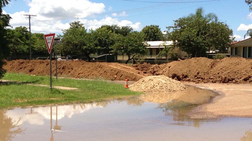 Floodwaters cover part of a road near a temporary levee in St George
