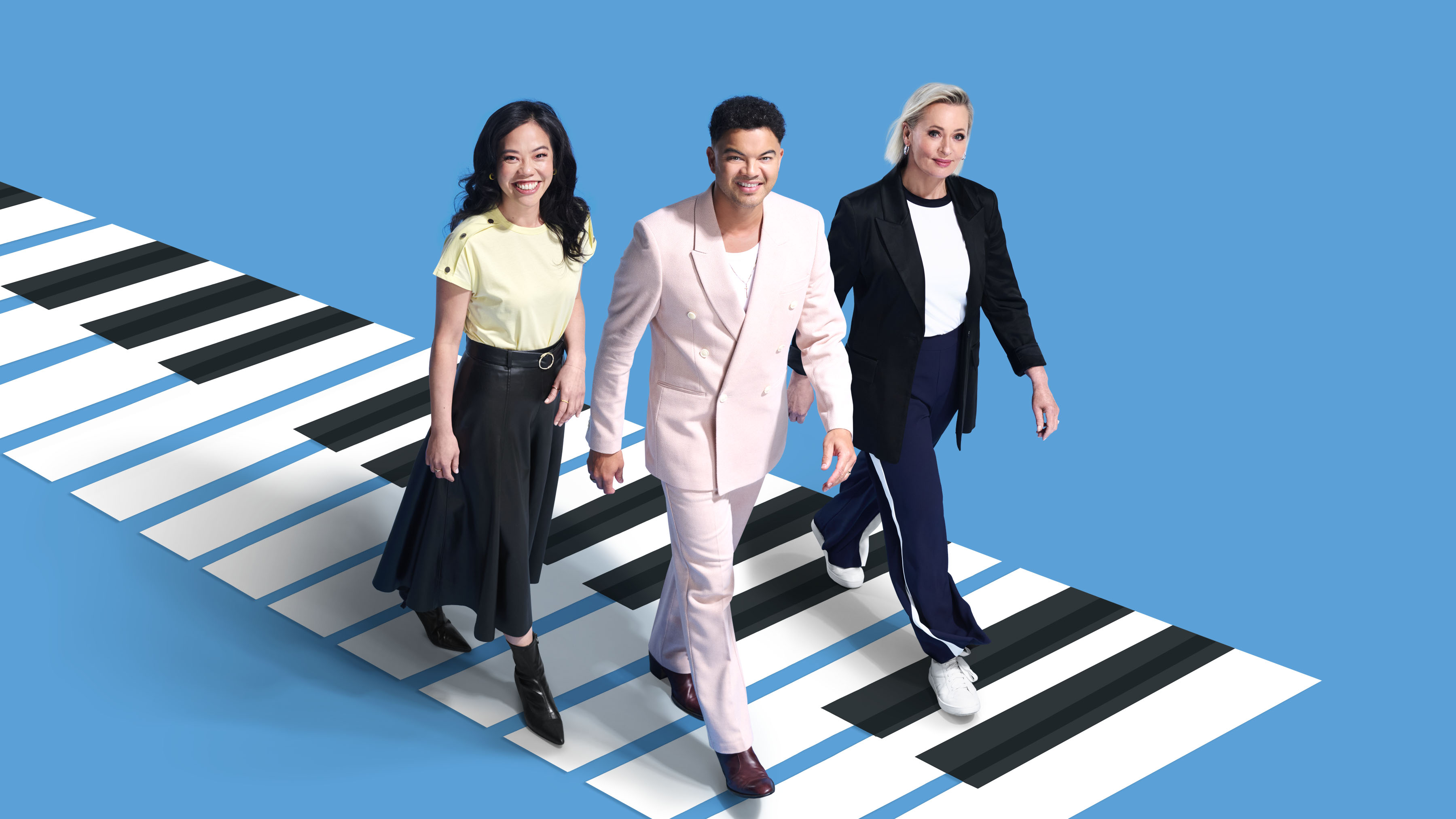 Andrea Lam, Guy Sebastian and Amanda Keller walking over giant piano keys
