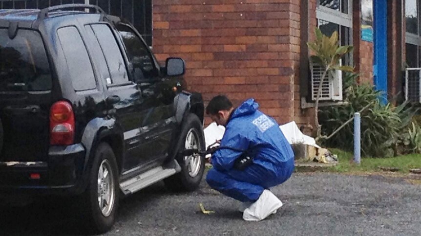 Forensic police examine a car at the crime scene on Quarry Rd, Murwillumbah