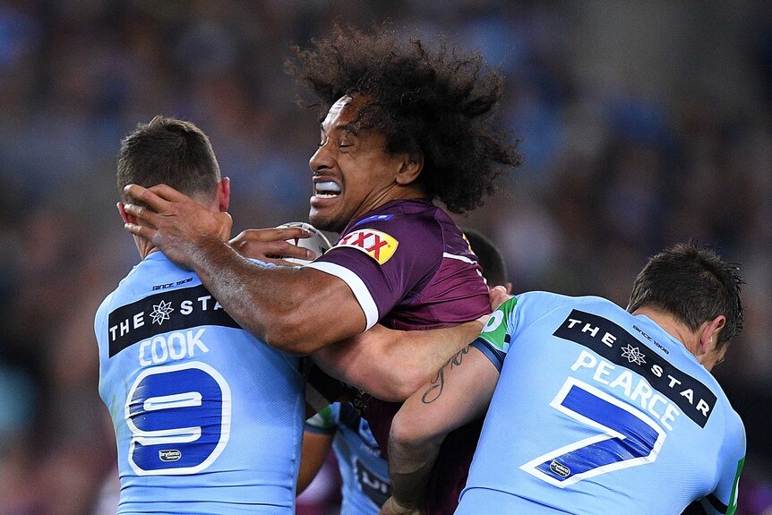 Felise Kaufusi is tackled by Damien Cook and Mitchell Pearce.