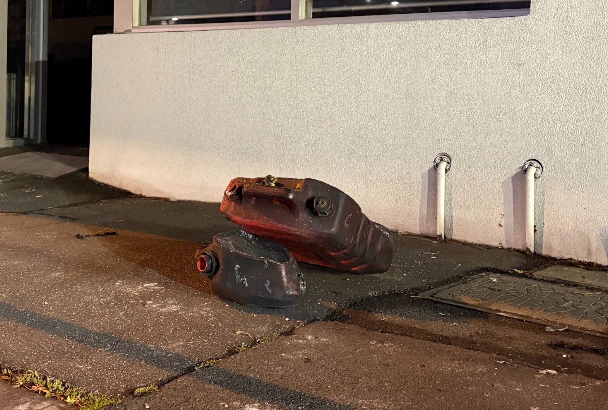 Discarded fuel containers on the ground outside a building
