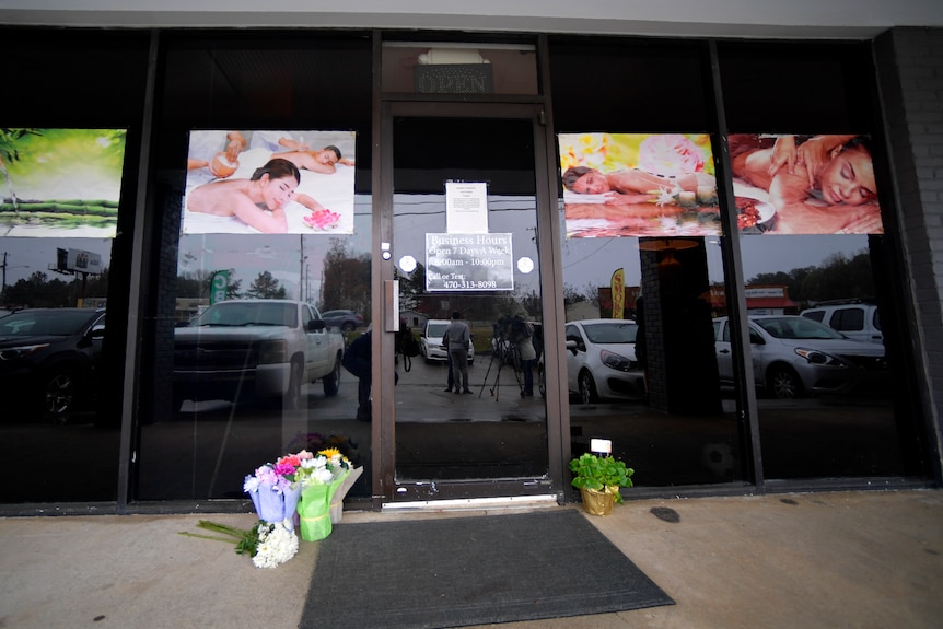 A make-shift memorial with flowers is seen outside a massage business.