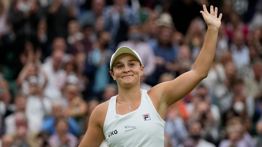Ash Barty smiles and waves to the Wimbledon crowd.