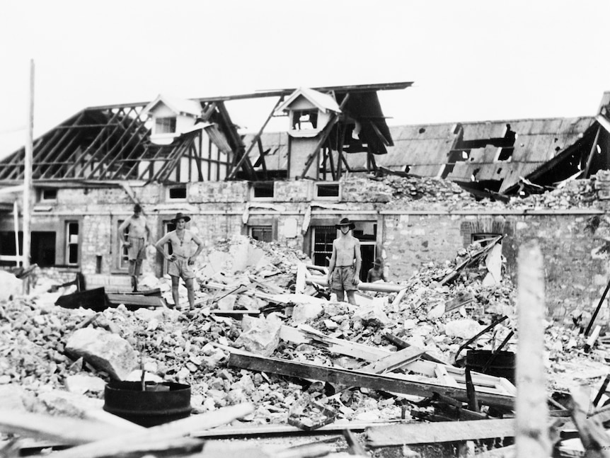Australian troops inspect bomb damage caused by Japanese air raids