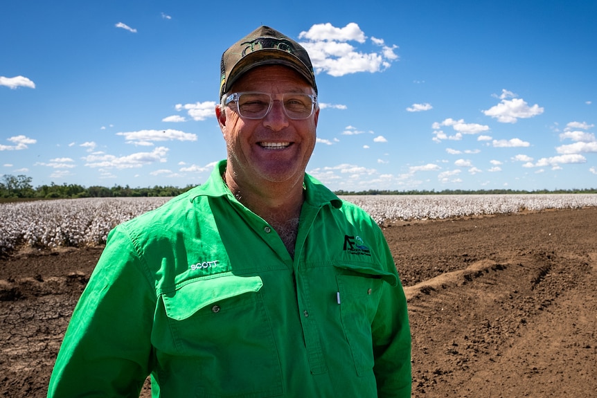 Image of a man wearing a green shirt in front of a paddock.