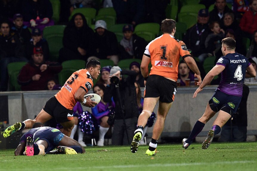 Tim Simona runs in to score a try for Wests Tigers