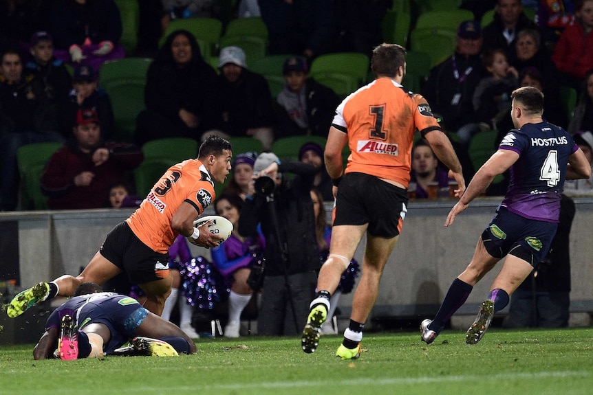 Wests Tigers' Tim Simona (L) scores a try against Melbourne Storm at AAMI Park.