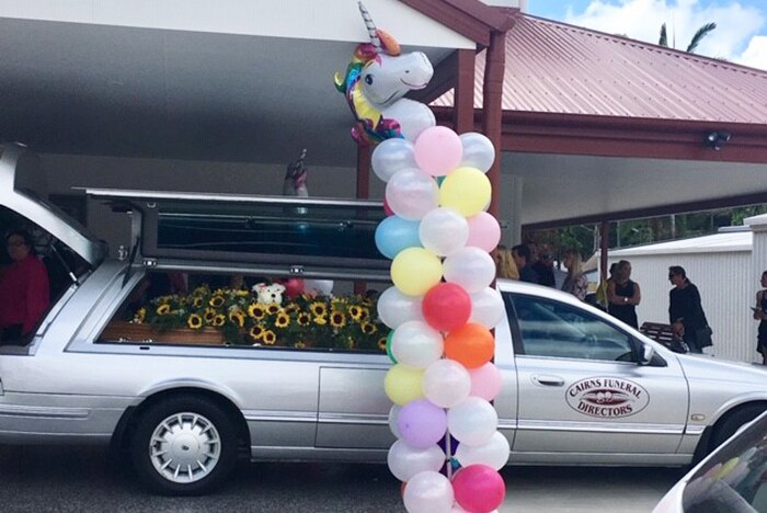Hearse with Toyah Cordingley's coffin inside, decorated with sunflowers and a unicorn balloon display at venue.