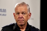 A man with white hair wearing a police uniform