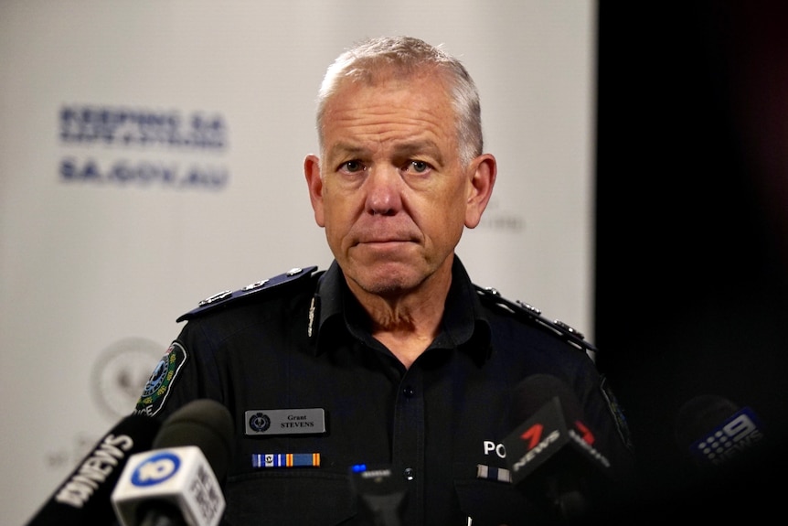 A man with white hair wearing a police uniform