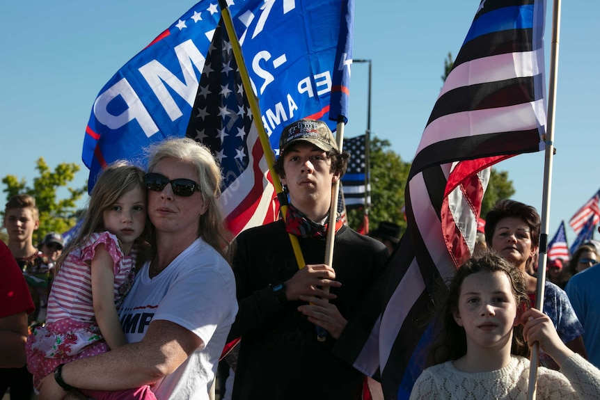 Supporters of President Donald Trump of different ages with the American flag.