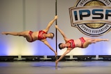Jude Perrett and Amy Davidson hanging from a singe pole 