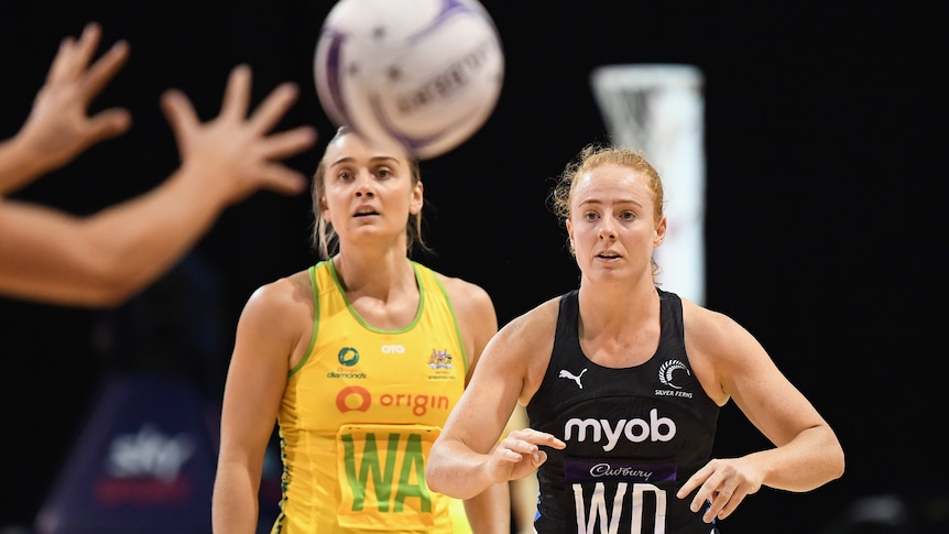 Sam Winders passes the ball to a teammate as she stands beside Diamonds captain Liz Watson
