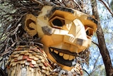 A close up of a massive wooden sculpture of a human face