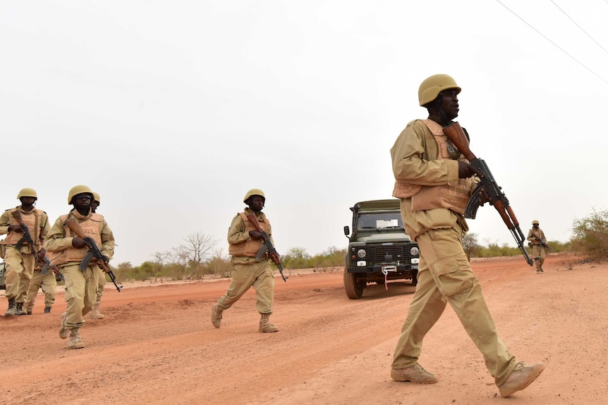 Soldiers in Burkina Faso crossing a road.