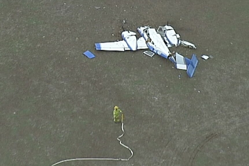 Aerial footage shows a firefighter and the wreckage of an aircraft.