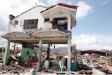 Survivors stay in their house damaged by Typhoon Haiyan.
