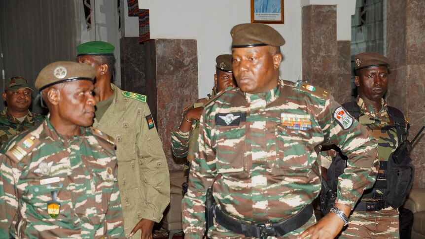 Abdourahmane Tiani in military gear surrounded by four other men also in army uniform. 