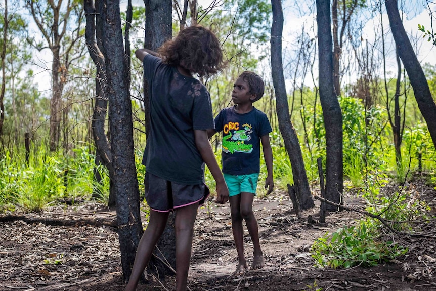 Two children play among the trees in Kakadu National Park
