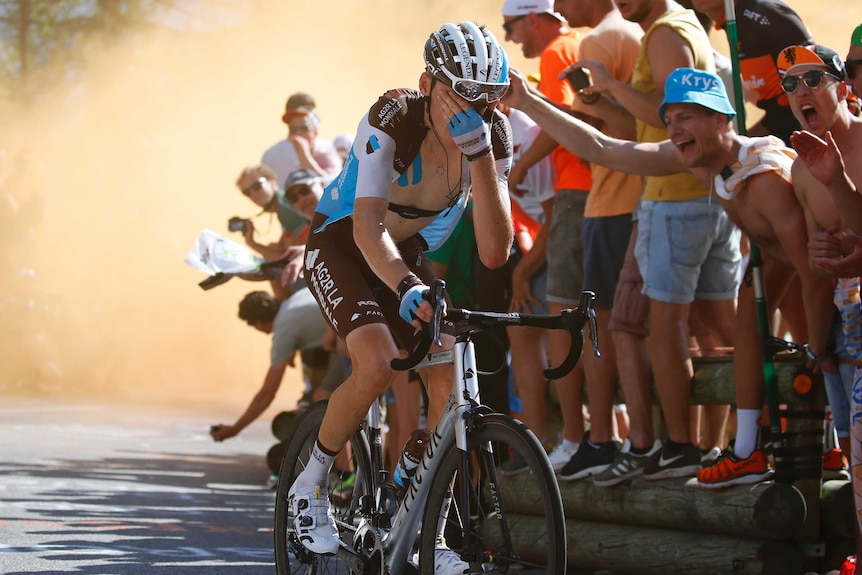 Romain Bardet rides through flare smoke during Tour de France