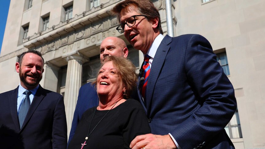Gail Ingham celebrates the win with her legal team outside the courthouse