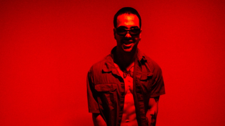 an image somber hills standing in a red room wearing red clothes