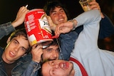 Boys drinking out of beer keg