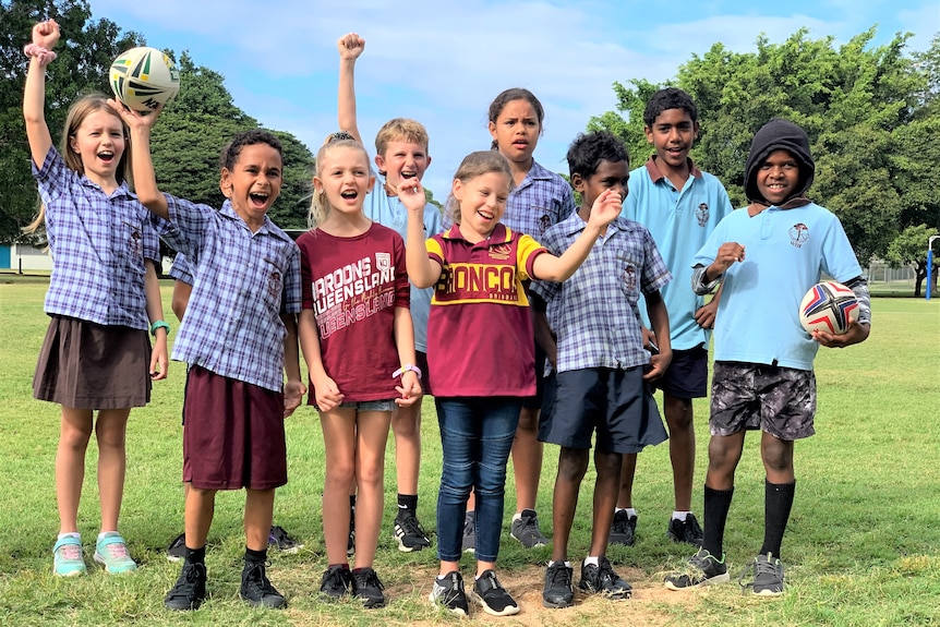 a group of primary school children cheering, dressed in Blue and Maroon cheering.