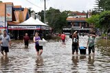 People walk through the floodwaters at Rosalie village