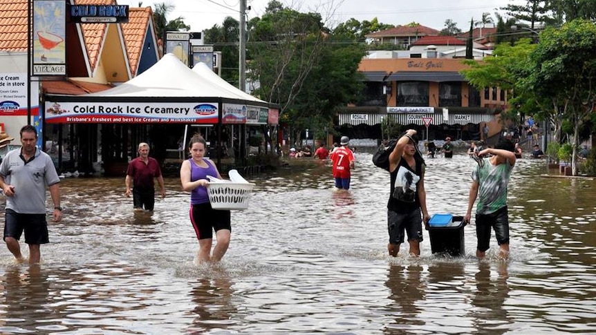 People walk through the floodwaters at Rosalie village in inner Brisbane on January 12, 2011.